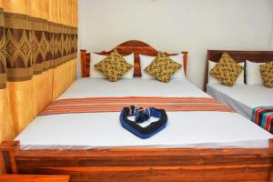 2 camas en una habitación con una bolsa en la cama en Passion Ray Villa & Tree Hut en Sigiriya