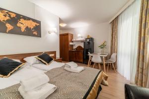 a hotel room with two beds and a table at AL-DOM apartamenty Apartament GOLD in Kołobrzeg