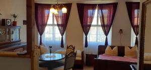 - une chambre avec un lit, une table et des fenêtres dans l'établissement Schloss Ottendorf, à Bahretal