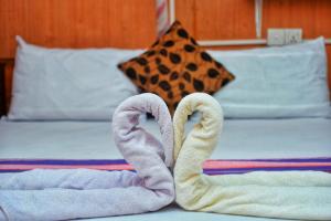 Dos cisnes hechos de toallas en una cama en Passion Ray Villa & Tree Hut, en Sigiriya