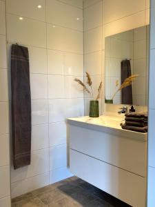 uma casa de banho com um lavatório e um espelho em Hotell Magasin 1 em Mörbylånga