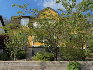 une maison jaune avec un arbre devant elle dans l'établissement Hotell Magasin 1, à Mörbylånga