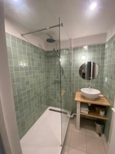 een badkamer met een glazen douche en een wastafel bij Hôtel Bellevue Cap d'Agde in Cap d'Agde