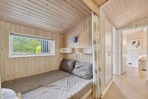 uma cama numa pequena casa com uma janela em Classic Summer House 200 Meters From The Water, em Børkop