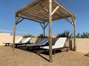 two lounge chairs under a wooden pavilion at the beach at Hôtel Bellevue Cap d'Agde in Cap d'Agde