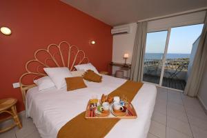 a bedroom with a bed with a view of the ocean at Hôtel Bellevue Cap d'Agde in Cap d'Agde