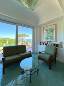 ein Wohnzimmer mit einem Sofa und einem Glastisch in der Unterkunft Resort Terme La Pergola in Ischia