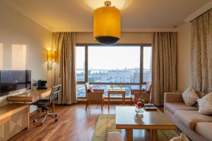 ein Wohnzimmer mit einem Sofa und einem Tisch in der Unterkunft Golden Tulip Dammam Corniche Hotel in Dammam