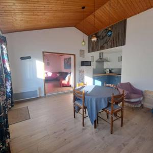 a room with a table and chairs and a living room at Maison de pêcheur au calme in Brétignolles-sur-Mer