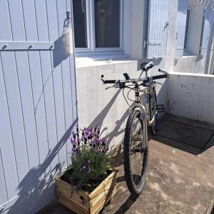 a bike parked next to a house with flowers at Maison de pêcheur au calme in Brétignolles-sur-Mer +44 photos