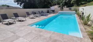une grande piscine avec des chaises dans l'établissement Appartement N° 1 avec jardin privé LES BOIS DE ZOLA, à Saint-Estève-Janson