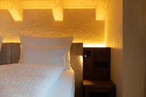 Cama blanca en habitación con ventana en Camino Rustic Chic Hotel en Livigno
