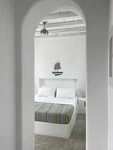 a bedroom with a white bed and an archway at MAGGANARI MOMENTS 2 in Manganari