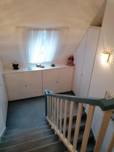 a room with a staircase with a window and a cat on a shelf at Kampweg 1 Wohnung 1 in Cuxhaven