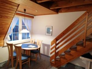a dining room with a table and chairs and a staircase at Kampweg 1 Wohnung 1 in Cuxhaven