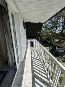 a porch of a house with a white railing at Kampweg 1 Wohnung 1 in Cuxhaven +7 photos