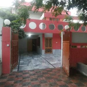 - un bâtiment rouge et blanc avec un portail et une cour dans l'établissement Peridot Cottage, à Islamabad