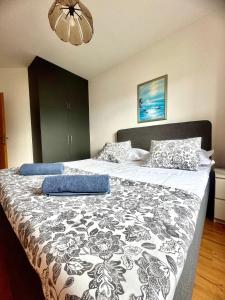 1 dormitorio con 1 cama con edredón blanco y negro en Apartments Glavaš, en Makarska
