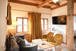 ein Wohnzimmer mit Sofa, Sesseln und Fernseher in der Unterkunft Mühle Tornow am Wentowsee in Tornow