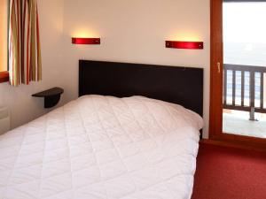 a bedroom with a white bed and a window at Chalet mitoyen aux Orres 1800 avec piscine, sauna, hammam, parking et prestations incluses - FR-1-322-102 in Les Orres +10 photos