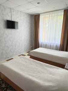 a hotel room with two beds and a television at Hotel Vesta in Brovary