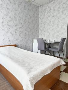 a bedroom with a bed and a table and chairs at Hotel Vesta in Brovary