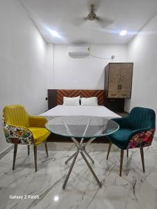 a bedroom with a table and two chairs and a bed at Motel Ilika in Bilāspur