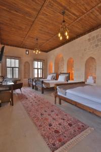 a large room with two beds and a table at Marvel Hotel in Mardin