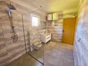 a bathroom with a toilet and a glass shower at Apartment Bijela ladja in Bihać +104 photos