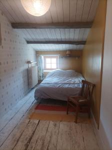 een slaapkamer met een bed, een stoel en een raam bij Maison familiale en centre-ville in Rochefort