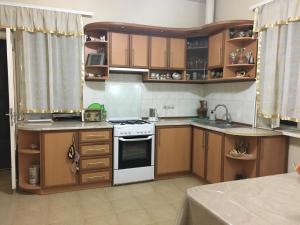 a kitchen with wooden cabinets and a white stove top oven at Private Guesthouse in Historic Village in Aghtsʼkʼ