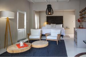 1 Schlafzimmer mit einem Bett, 2 Stühlen und einem Tisch in der Unterkunft Macaron Boutique Guest House in Franschhoek