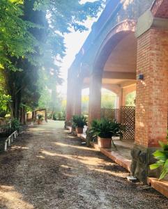 a brick building with an arch with potted plants at Villa I Tigli Appartamenti in Campiglia Marittima
