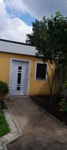 un edificio blanco y amarillo con garaje en Alivio - Thuiskomen bij jezelf op vakantie, en Lummen