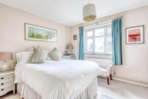 sypialnia z białym łóżkiem i oknem w obiekcie Comfortable Home in Wandsworth by UndertheDoormat w Londynie