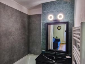 a bathroom with a bath tub and a mirror at Studio Côté Ville in Le Bourg-dʼOisans
