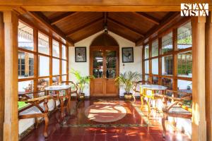 a lobby with tables and chairs and a wooden door at StayVista at Greenwood Bungalow - Indoor & Outdoor Game in Ooty