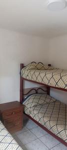 two bunk beds in a room with a wooden table at Cabañas Don Alex in Maitencillo +5 photos
