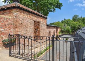 an iron gate in front of a brick building at Hill Farm Retreat in Wangford