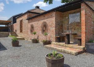 a brick building with potted plants in front of it at Hill Farm Retreat in Wangford