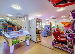 uma sala de jogos para crianças com jogos de arcada e máquinas em Freshwater Beach Holiday Park em Burton Bradstock