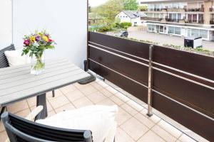 a balcony with a table and a vase of flowers at Syltdomizil Morgensonne in Wenningstedt