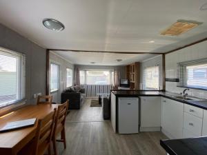 a kitchen and living room with a table and a dining room at Homely Caravan Just A Short Walk To Hembsy Beach In Norfolk Ref 00036ba in Hemsby