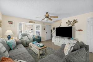 a living room with a couch and a flat screen tv at Bellas Beach House in Panama City Beach