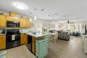 a kitchen with yellow cabinets and a living room at Bellas Beach House in Panama City Beach