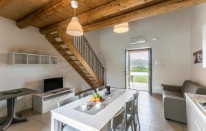 cocina y sala de estar con mesa blanca y sillas en Oriental Muti en Chiaramonte Gulfi