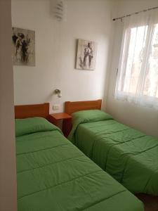 - 2 lits dans une chambre avec des draps verts dans l'établissement CASA IDEALE, à Raguse