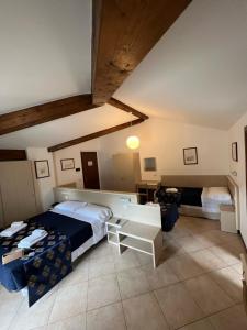 een slaapkamer met 2 bedden en een tafel. bij Hotel Merloni in Grandola ed Uniti