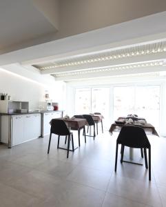 a white kitchen with tables and chairs in a room at B&B Sunlight Tropea in Tropea