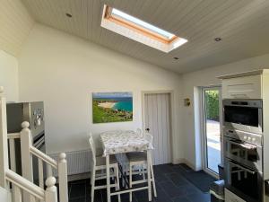 a kitchen with a table and chairs and a skylight at House Gowlane in Castlegregory